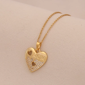 Detailed close-up of a gold heart pendant featuring sparkling zircon and MOM engraving