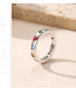 Macro shot of s925 silver ring with colorful heart gemstones on natural stone background