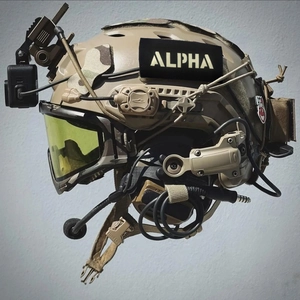 Tactical helmet in tan color with integrated camera mount and headset on grey background