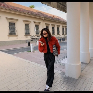 Chic red faux mink fur jacket with black turtleneck and trousers in street style