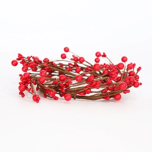 Detailed view of red artificial berries and brown branches on a festive candle ring wreath