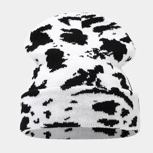 Detailed view of thick knit beanie with black and white animal print pattern