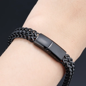 Detail of black stainless steel woven bracelet featuring a sleek rectangular magnetic clasp