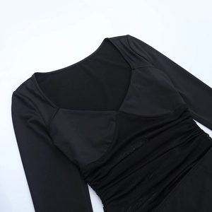 Détail du décolleté en cœur et patchwork en mesh sur la robe noire à manches longues