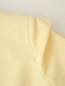 Vue macro du tissu tissé jaune clair montrant la texture fine et les coutures