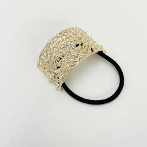 Detailed close-up of hollow metal hair tie with faux pearls and rhinestones