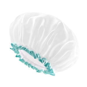 Detail view of double-layered waterproof shower cap with elastic turquoise ruffled trim