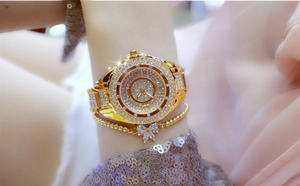 Detailed shot of luxury gold watch with rhinestones and butterfly charm bracelet set