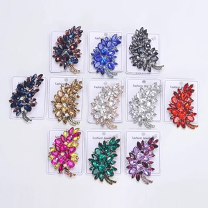 Detail of leaf-shaped brooches featuring colorful crystals on fashion jewelry cards
