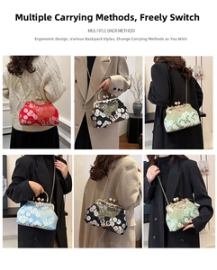 Dettaglio della borsa kiss-lock con ricami floreali e manico in metallo elegante