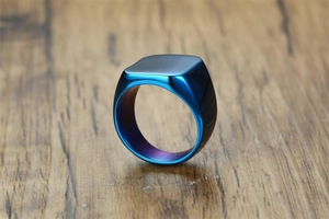 Macro shot of polished blue gradient square signet ring on a wooden background