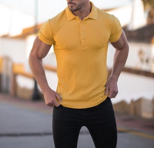 Detail of men's slim fit mustard yellow rib knit polo shirt shown on model outdoors