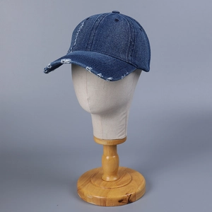 Distressed dark blue denim baseball cap with ripped holes and casual frayed brim