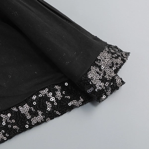 Close-up of black sequin embellishments on the hemline of a sexy slit dress