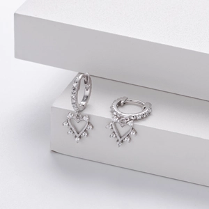 Detailed view of silver S925 heart earrings with pavé zircons on geometric blocks