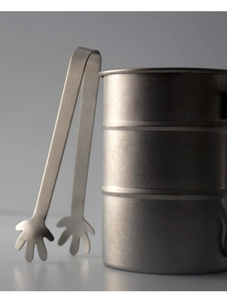 Close-up of stainless steel palm-shaped ice tongs and matching silver metal bucket