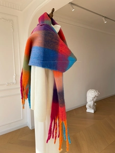 Close-up of vibrant gradient plaid scarf with long tassels and soft fuzzy texture