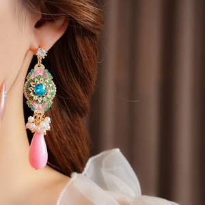 Gros plan sur des boucles d'oreilles vintage avec pierres bleues, fleurs et perles