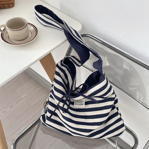 Detail of navy striped canvas tote bag with drawstring closure and fabric brand label