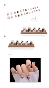 Détail de faux ongles de luxe avec cœurs noirs, nœuds 3D et accents de perles
