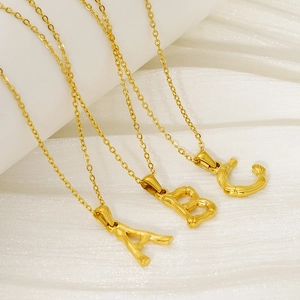 Detail of 18k gold plated stainless steel pendants featuring A, B, C bamboo textures
