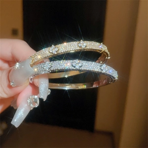 Close-up of sparkling zircon flower bracelets in gold and silver finish with crystal details