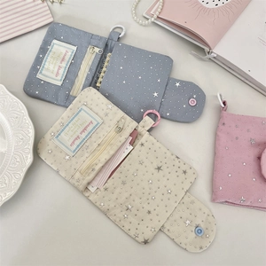 Detail of star-patterned fabric card holders with snap buttons and zip pockets