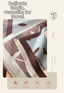 Detailed texture of imitation cashmere scarf featuring brown leaf pattern and fringe tassels