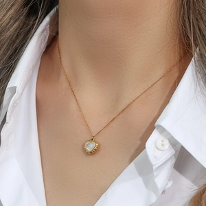 18K gold plated necklace with vintage heart shell pendant on a model's collarbone