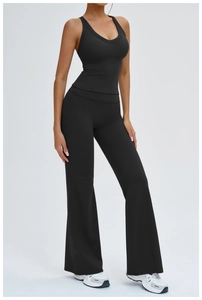 Détail d'un haut de sport noir à col en V et d'un pantalon de yoga évasé sur modèle