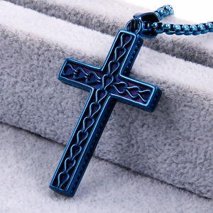 Macro detail of blue stainless steel cross pendant with hollow woven texture design