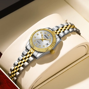 Detail of a two-tone quartz watch featuring a white dial, diamond markers, and date window