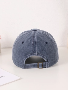 Detailed back view of washed denim baseball cap with metal buckle and white stitching