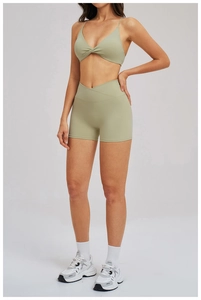 Detail of olive green yoga set featuring a twisted sports bra and V-cross waist shorts