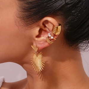 Close-up of 18K gold cactus and heart earrings set with decorative ear cuffs on model