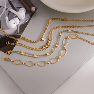 Dettaglio di quattro bracciali in acciaio inossidabile 18K placcati oro con intarsio in zircone