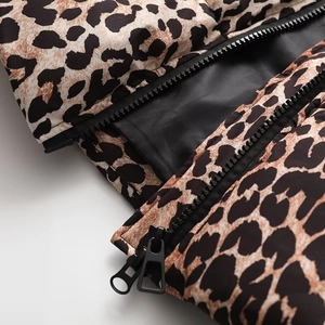 Vue détaillée du zip double noir et de la texture léopard sur la veste matelassée