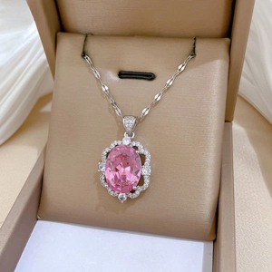 Detail of pink oval gemstone pendant with micro-pave diamond halo in a gift box