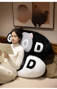 Detail of plush black and white pillows with 'GOOD' embroidery on a cozy bedroom bed