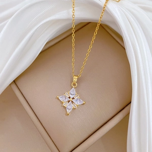 Elegant gold clover star pendant necklace with sparkling cubic zirconia on white silk
