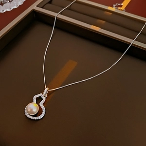 Detail of silver gourd necklace with zircon pavé and center pearl in a gift box