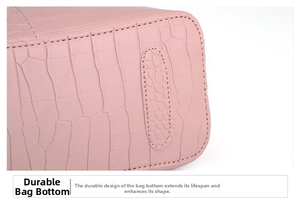 Close-up detail of wear-resistant base on pink crocodile texture handbag with neat stitching