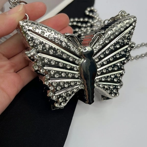 Detail of silver butterfly-shaped rhinestone clutch bag with elegant metal chain strap