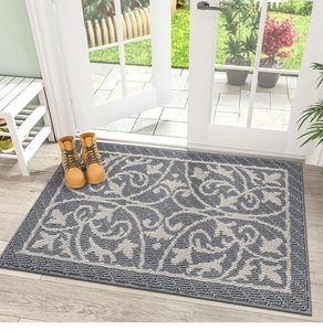 Detalle de alfombra de polipropileno gris con motivos clásicos en suelo madera