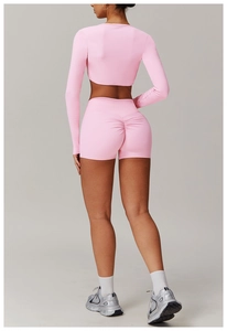 Rear view of pink yoga set featuring high-waisted scrunch butt shorts and cropped long sleeve