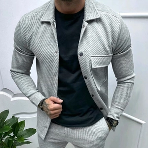 Detail showing the heavy twill texture and single-breasted buttons of the light grey jacket