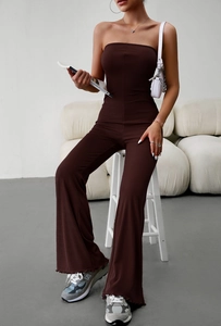 Detail of brown ribbed knit strapless jumpsuit featuring elegant flared ruffles at the hem