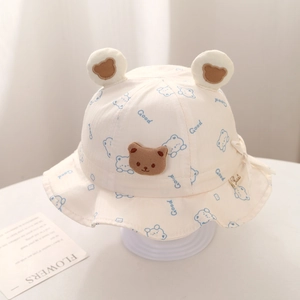 Detail of white cotton baby sun hat featuring 3D bear ears and blue Good print