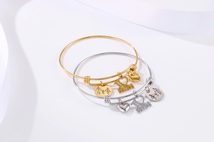 Detailed view of gold and silver heart bracelets with family charms for Mother's Day