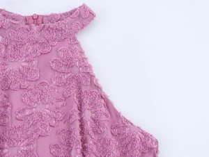 Detail view of pinkish purple floral textured fabric and hidden zipper on halter dress